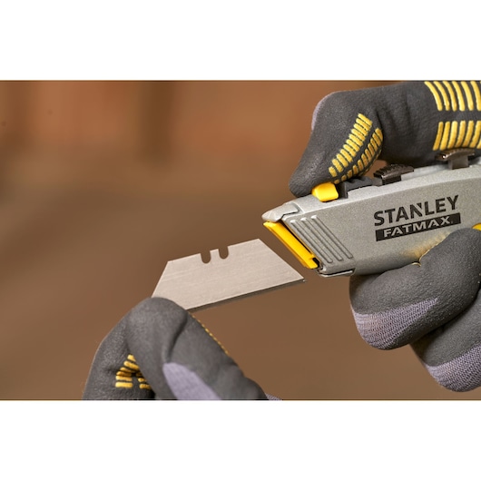 STANLEY 0-10-789 utility knife blade being changed, close-up, with gloved hands.