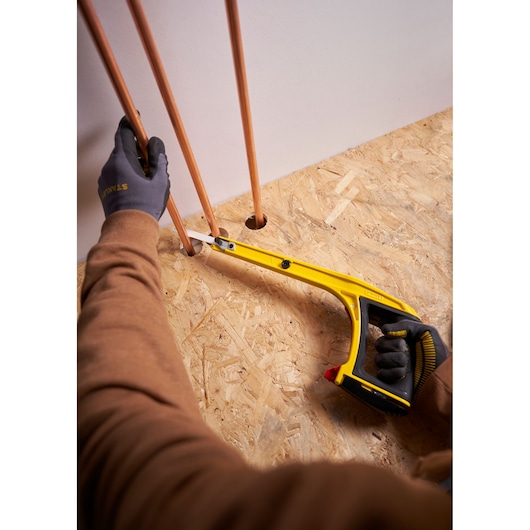 STANLEY 0-20-108 hacksaw used for cutting copper pipe, photographed from above during installation work.