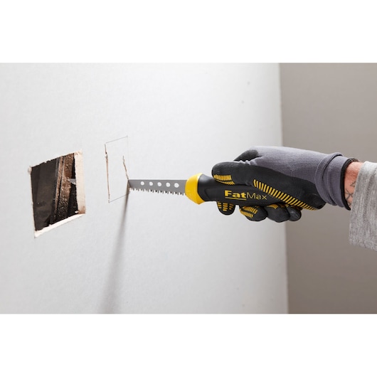 STANLEY 0-20-556 FatMax drywall saw cutting rectangular hole in wall, side angle, black and yellow handle.