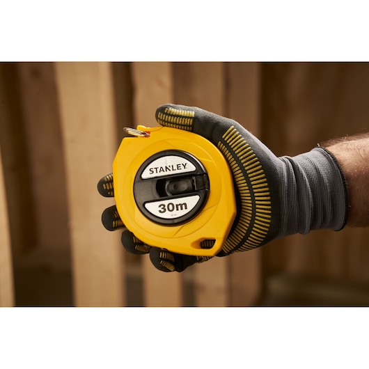 STANLEY 0-34-108 yellow 30m tape measure, photography showing tool held in a gloved hand.
