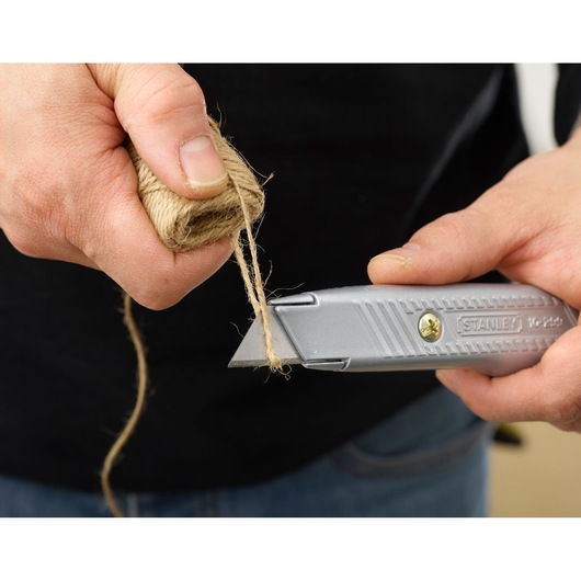 Photo of STANLEY 2-10-199 utility knife cutting twine, close-up of hands and tool in use.
