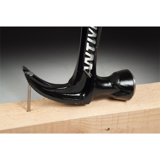 STANLEY FMHT1-51277 claw hammer removing nail from wood, close-up side view.