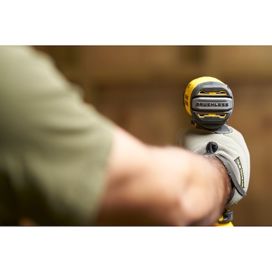 Photo of STANLEY SFMCF810B brushless drill in gloved hand, close-up view with focus on rear housing.