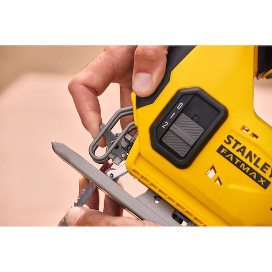 Photo of STANLEY SFMCS600B FATMAX jigsaw, yellow and black, close-up of blade adjustment and control dial.