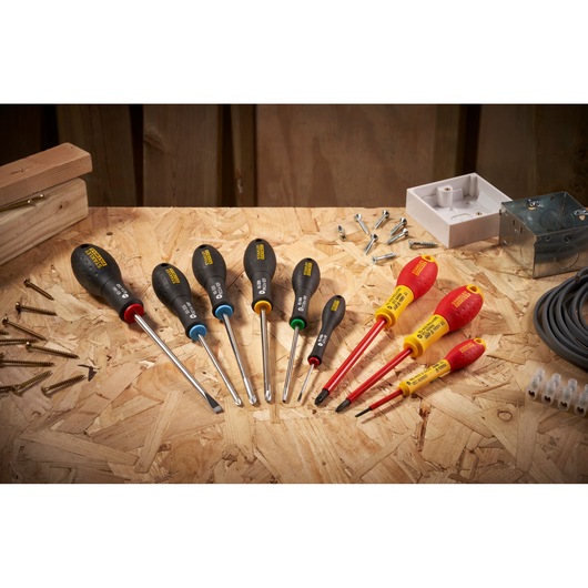STANLEY 0-65-337 screwdriver set with black and red handles on a workshop table, photographed overhead.